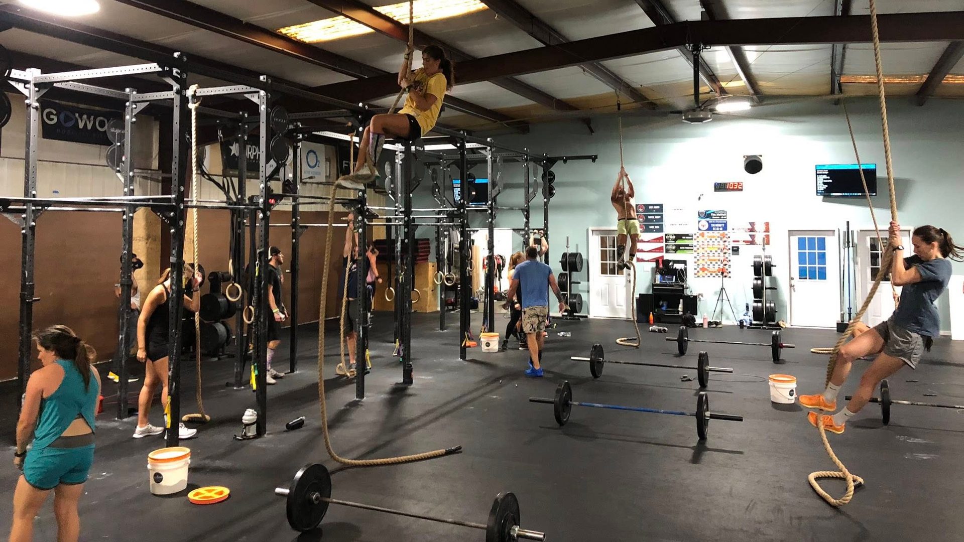 Members mid-class on the Lodestar floor, two of them partway up the climbing ropes