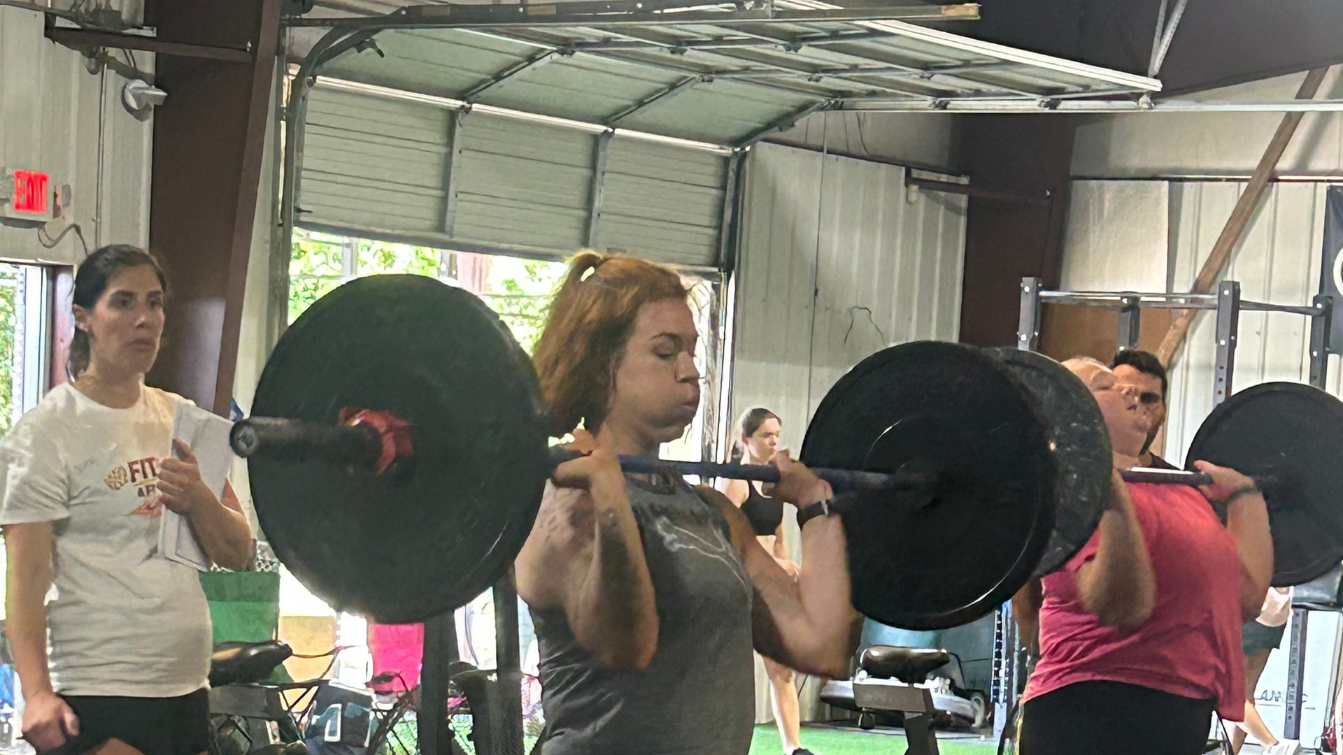 A member holding a barbell in the front rack during a lifting session at Lodestar